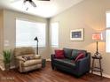 Cozy living room featuring a recliner, sofa, and natural light from a large window at 2416 N Snead Dr, Mesa, AZ 85215