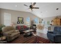 Spacious living room featuring a ceiling fan, wood and tile flooring, and seamless flow to the dining area at 2416 N Snead Dr, Mesa, AZ 85215