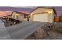 Charming home showcasing a spacious brick driveway leading to a two-car garage during sunset at 26199 S 227Th St, Queen Creek, AZ 85142