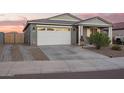 View of home exterior featuring a spacious driveway and a two-car garage at 28883 N 131St Dr, Peoria, AZ 85383