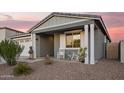 Charming front porch featuring rocking chairs with decorative shutters and columns at 28883 N 131St Dr, Peoria, AZ 85383