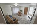 Inviting living room with cozy sofa, recliner, front door, large window with blinds and wood-look flooring at 2907 S Elm St, Tempe, AZ 85282