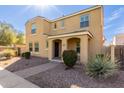 Tan two-story home with a covered porch entry, desert landscaping, and brick paver walkway at 3555 E Erie St, Gilbert, AZ 85295