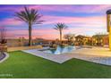Stunning backyard oasis featuring a sparkling pool, lush turf, and cozy outdoor seating, perfect for entertaining at 7055 E Ivyglen Cir, Mesa, AZ 85207