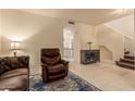 Inviting living room featuring a leather recliner, arched entryway, and tile floors with a decorative rug at 7304 E Northridge Cir, Mesa, AZ 85207