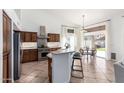 Well-lit kitchen with stainless steel appliances, breakfast bar, and a dining area with backyard access at 741 W Harvard Ave, Gilbert, AZ 85233