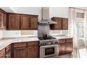 Close-up of kitchen features stainless steel oven and range with vent hood, and beautiful wood cabinets at 741 W Harvard Ave, Gilbert, AZ 85233