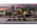 Charming single-story home boasting stone accents, neutral colors, and professional landscaping at dusk at 834 E Kachina Trl, Phoenix, AZ 85042