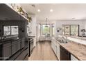 Spacious kitchen featuring white cabinets, black appliances, and a cozy breakfast nook at 9260 E Greenway St, Mesa, AZ 85207
