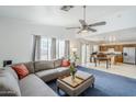 Open-concept living room with blue carpet, grey couch, and vaulted ceilings at 9405 W Palmer Dr, Peoria, AZ 85345