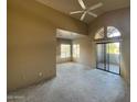 Bright living room featuring a vaulted ceiling, arched window and sliding glass door to outdoor space at 9600 N 96Th St # 270, Scottsdale, AZ 85258