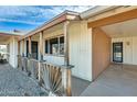 Welcoming covered porch with decorative wood railing, providing a cozy entrance to the home at 10025 W Alabama Ave, Sun City, AZ 85351