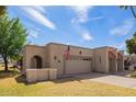 Charming home with a two-car garage, American flag, and desert landscaping at 10127 E Minnesota Ave, Sun Lakes, AZ 85248