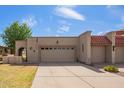 Charming home with a two-car garage, American flag, and desert landscaping at 10127 E Minnesota Ave, Sun Lakes, AZ 85248