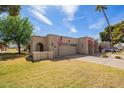 Charming home with a two-car garage, American flag, and desert landscaping at 10127 E Minnesota Ave, Sun Lakes, AZ 85248