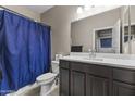 Cozy bathroom with a shower-tub combination, dark vanity with sink, toilet, and a large mirror at 10428 S 54Th Ln, Laveen, AZ 85339