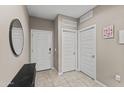 Inviting entryway features tiled floor, coat closet, and decorative mirror, offering a welcoming space at 10428 S 54Th Ln, Laveen, AZ 85339