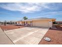 Home featuring a well-kept yard and a welcoming front porch with seating, plus a two car garage at 10511 W Edgewood Dr, Sun City, AZ 85351