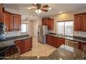 Open kitchen featuring stainless steel appliances, granite counters, and cherry wood cabinets at 11011 N Zephyr Dr # 106, Fountain Hills, AZ 85268