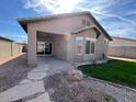 Cozy home exterior featuring a covered patio, rock landscaping, and small grassy area at 11946 W Jackson St, Avondale, AZ 85323