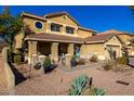 Charming two-story home featuring a cozy front porch and desert landscaping at 1202 E Milada Dr, Phoenix, AZ 85042