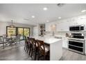 Spacious kitchen with white cabinets, stainless steel appliances, quartz countertops, and island with bar seating at 1202 E Milada Dr, Phoenix, AZ 85042