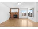 Inviting living room with a brick fireplace and plenty of natural light at 12215 S Potomac St, Phoenix, AZ 85044