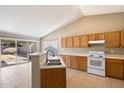 Bright, open kitchen with tile flooring, wood cabinetry, white appliances, and sliding glass doors to the backyard at 1301 N Jackson St, Chandler, AZ 85225