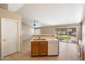 Open-concept kitchen includes a breakfast bar, white dishwasher, tile flooring, and a view of the adjacent living space at 1301 N Jackson St, Chandler, AZ 85225