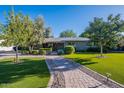 Inviting home exterior with lush green lawn, mature trees, and a charming walkway to the entrance at 1335 E Oregon Ave, Phoenix, AZ 85014