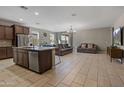 Open concept kitchen and living room with stainless steel appliances, tile flooring and modern decor at 13624 W Desert Moon Way, Peoria, AZ 85383