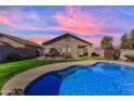 Beautiful backyard with a refreshing private pool, green lawn, and patio area perfect for outdoor entertaining at 151 N 116Th Dr, Avondale, AZ 85323