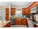 Well lit kitchen with an island, stainless steel appliances, granite countertops, and wood cabinets at 1600 N Saba St # 191, Chandler, AZ 85225