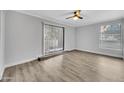 Well-lit living room with wood flooring, ceiling fan, and sliding glass doors overlooking the outdoor space at 17211 N 35Th Ave # 1035, Phoenix, AZ 85053