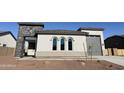 Attractive single-story home with gray trim, a stone archway, desert landscaping, and three arch windows at 17312 W Royal Palm Rd, Waddell, AZ 85355