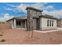 Inviting home exterior with a stone entry feature, neutral stucco, and a well-manicured front yard at 17312 W Royal Palm Rd, Waddell, AZ 85355