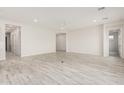 Bright and airy living room with wood-look tile flooring, neutral walls, and recessed lighting at 17312 W Royal Palm Rd, Waddell, AZ 85355