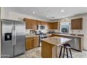 Well-lit kitchen featuring stainless steel appliances, a kitchen island with seating, and tile flooring at 1992 E Shetland Dr, San Tan Valley, AZ 85140