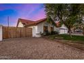 A single-Gathering home featuring a two-car garage, desert landscaping, and privacy fence at 2646 N Robin Ln, Mesa, AZ 85213