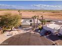 Aerial view of a desert home featuring mature trees, a two-car garage, and desert views at 26649 S Howard Dr, Sun Lakes, AZ 85248