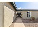 Inviting front entrance featuring a security gate, arched window, and desert-themed decorations at 26649 S Howard Dr, Sun Lakes, AZ 85248