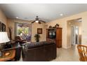 Cozy living room featuring a ceiling fan, tile flooring, and sliding glass doors to the patio at 27108 W Escuda Dr, Buckeye, AZ 85396