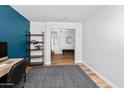 Office room showcasing a blue accent wall, sleek shelving, and seamless access to other rooms at 28871 N Coal Ave, San Tan Valley, AZ 85143