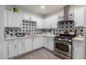 Bright kitchen features starburst backsplash, stainless steel appliances, and white cabinets at 3129 W Pierce St, Phoenix, AZ 85009