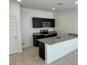 Modern kitchen featuring a sink island, granite counters, dark cabinets, and stainless steel appliances at 35436 N Breezy Ln, San Tan Valley, AZ 85140