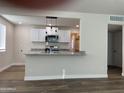 Open kitchen featuring white cabinets, granite countertops, and modern pendant lighting at 416 W Mission Ln, Phoenix, AZ 85021