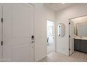 Bright entryway with a white door, light wood floors, and views into a bathroom and study at 6451 N 17Th Pl, Phoenix, AZ 85016