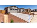 A view of the front of the house with desert landscaping and a two car garage at 8553 N 175Th Ln, Waddell, AZ 85355