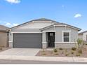 Charming single-story home with gray stucco, well-manicured landscaping, and a two-car garage at 8554 W Trenton Ct, Florence, AZ 85132