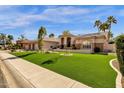 Charming single story home with lush green lawn and palm trees at 8657 E Aster Dr, Scottsdale, AZ 85260